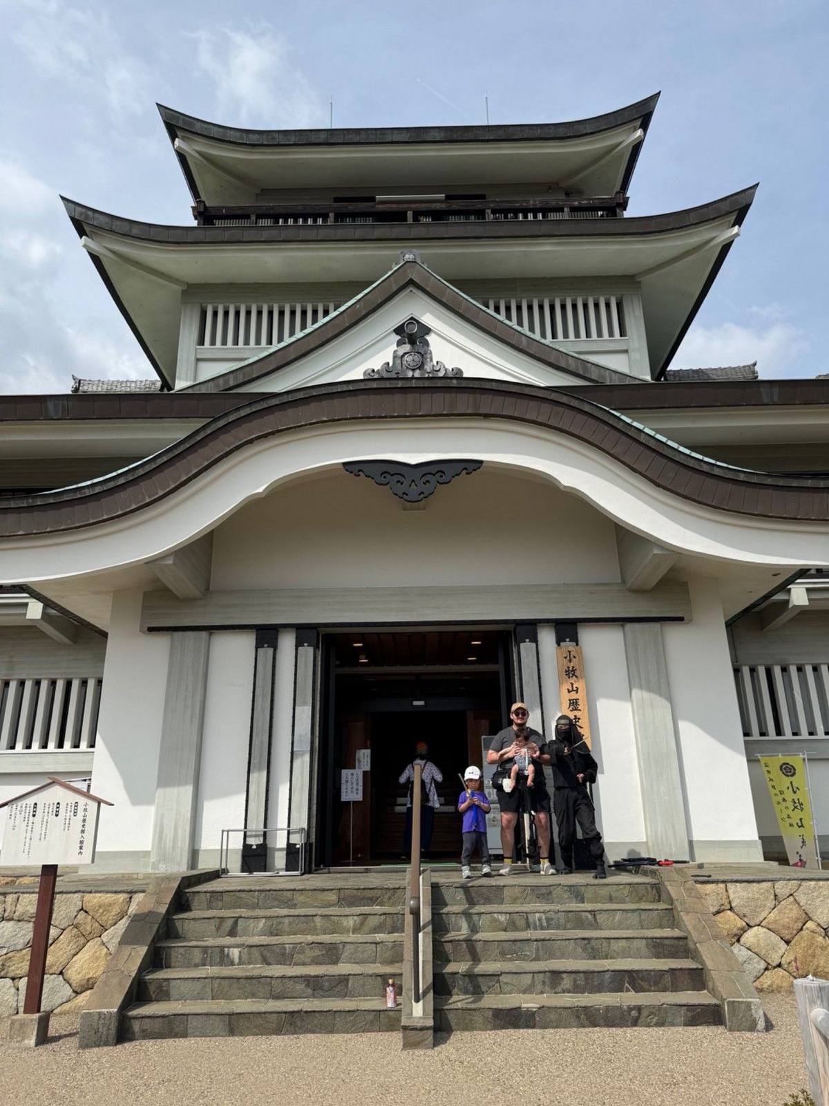 The castle-style Komakiyama Historical Museum at the summit of Komakiyama, with the author's family on the steps