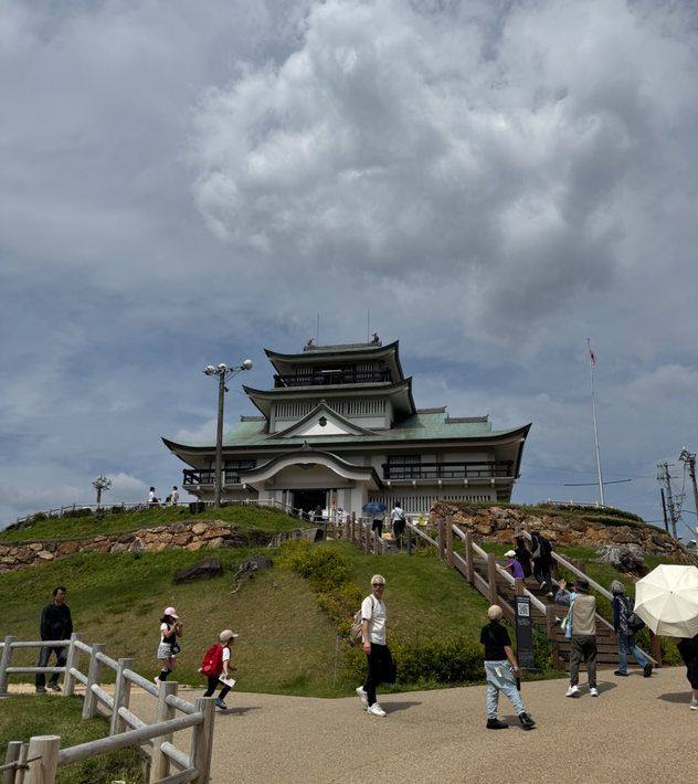 小牧山山頂の城郭風の資料館と、道を歩く来訪者